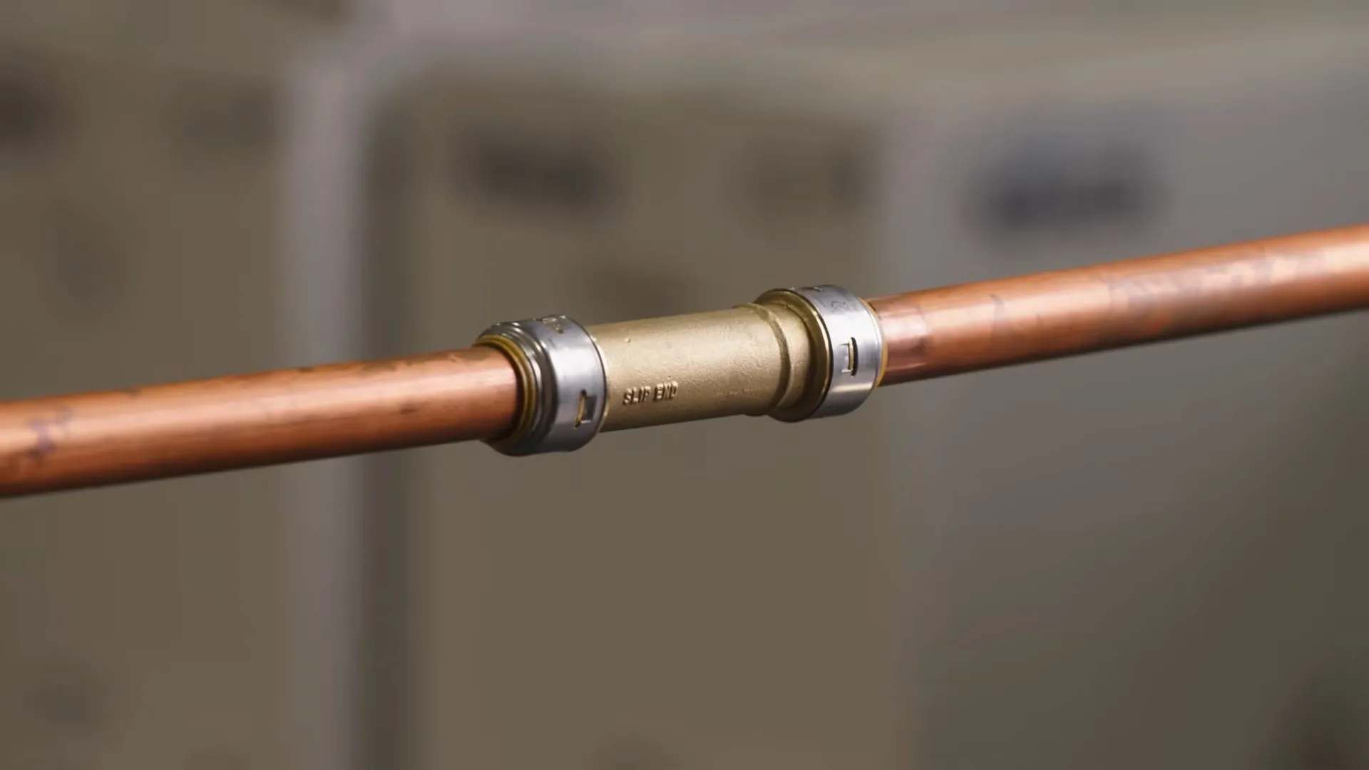 Brass push-fit coupling joining two lengths of copper pipe