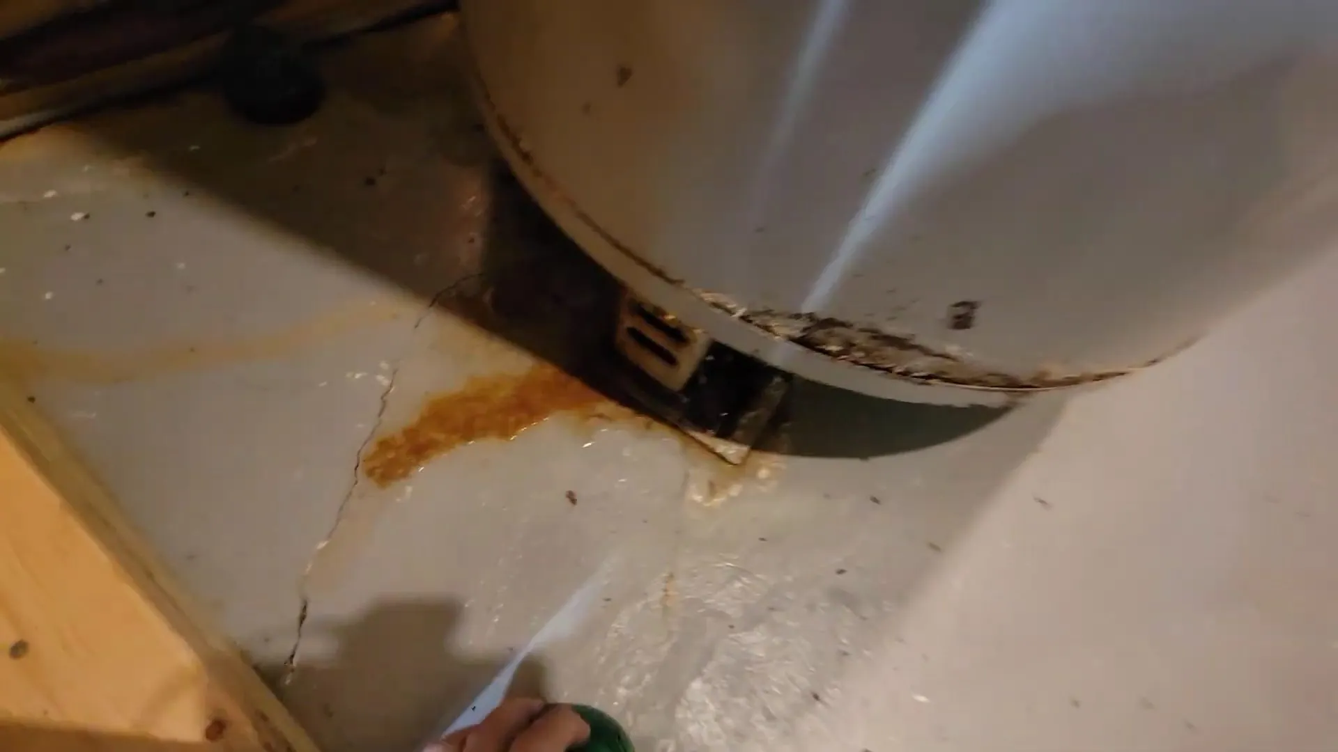 Rust stain on the floor beneath an older tank water heater