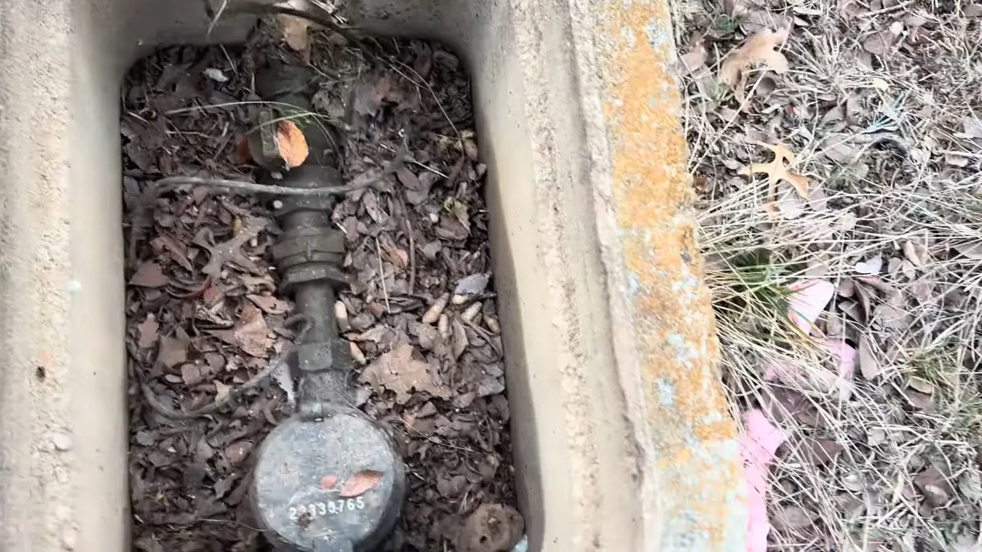 Water meter and shutoff inside a ground box with the lid removed